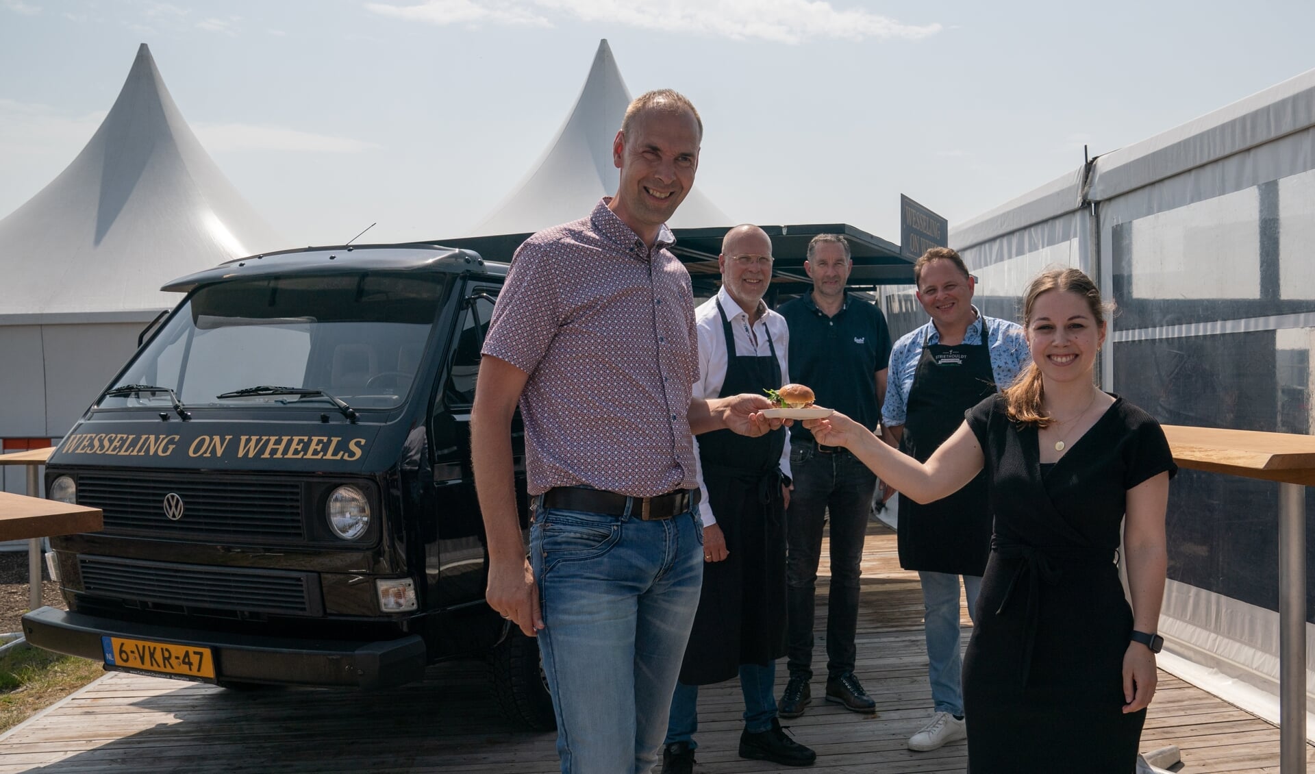 Koersdirecteur Thijs Rondhuis krijgt de eerste VAM-burger aangeboden door Iris Alferink (foto Kim Stellingwerf).