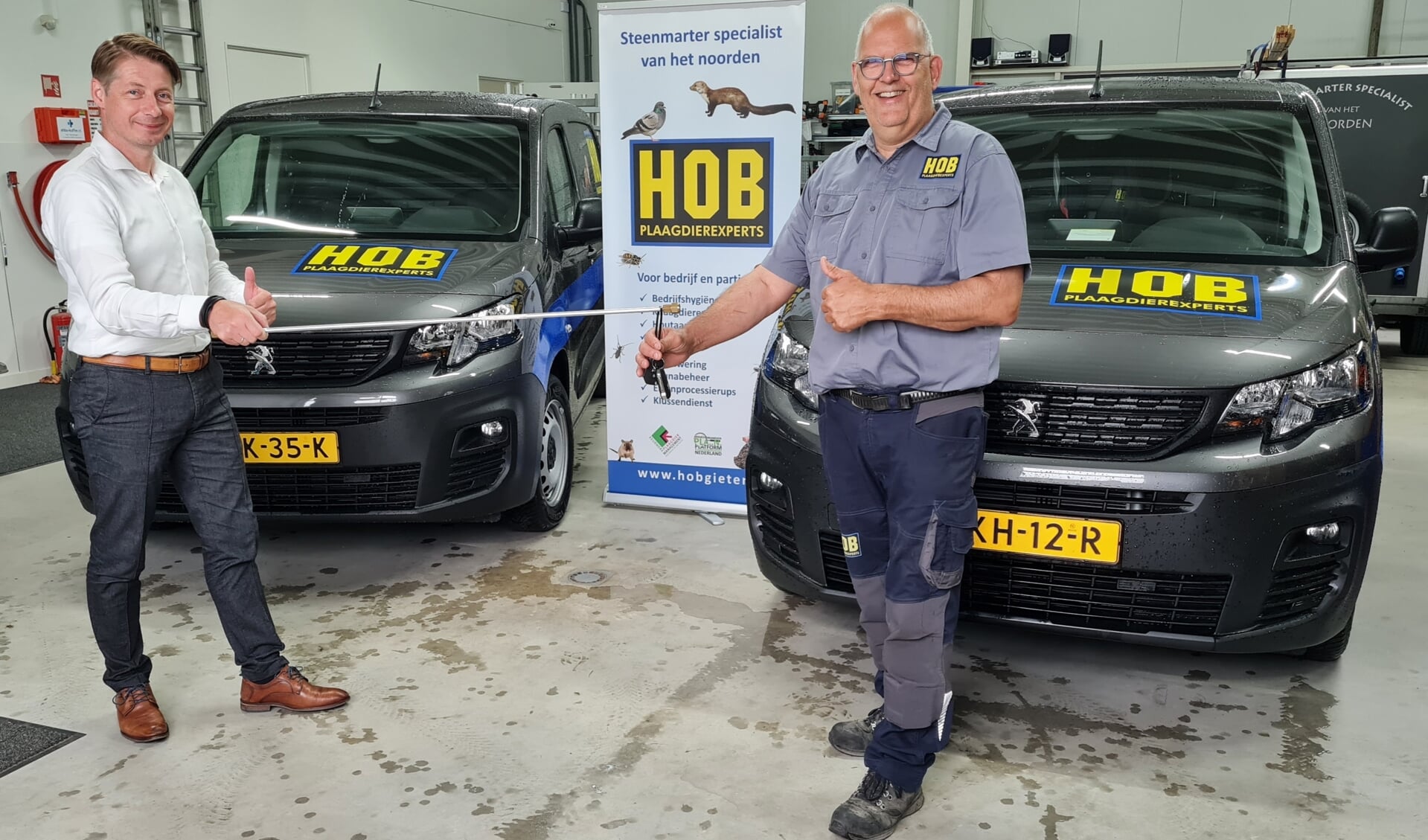 Hans Hoekstra krijgt de sleutels van zijn nieuwe bedrijfsauto's van Floris Mulder.