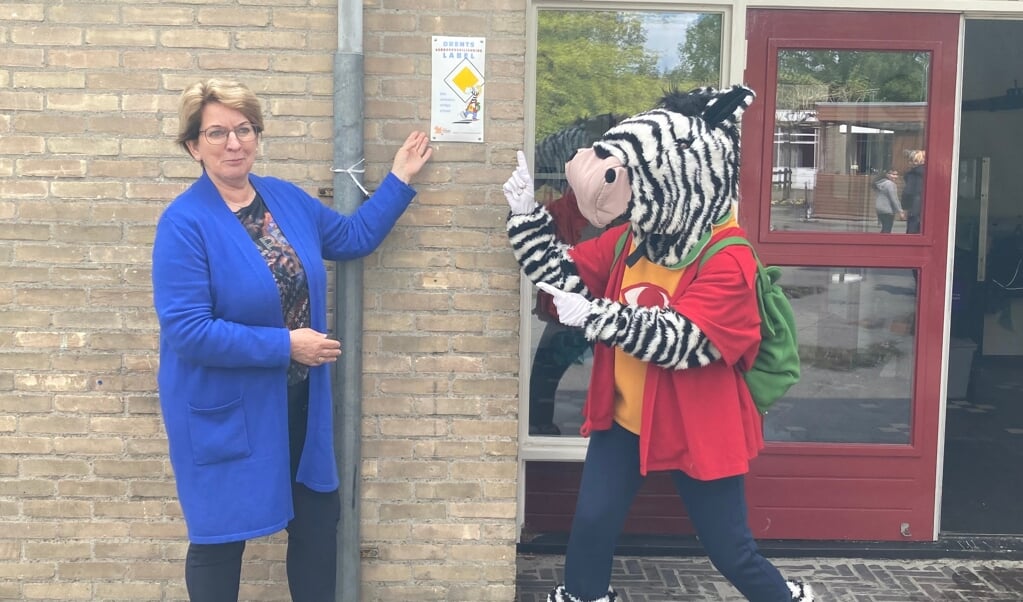Wethouder Nynke Houwing en mascotte Seef bij het verkeersveiligheidslabel voor De Zweng. (foto: gemeente Borger-Odoorn)