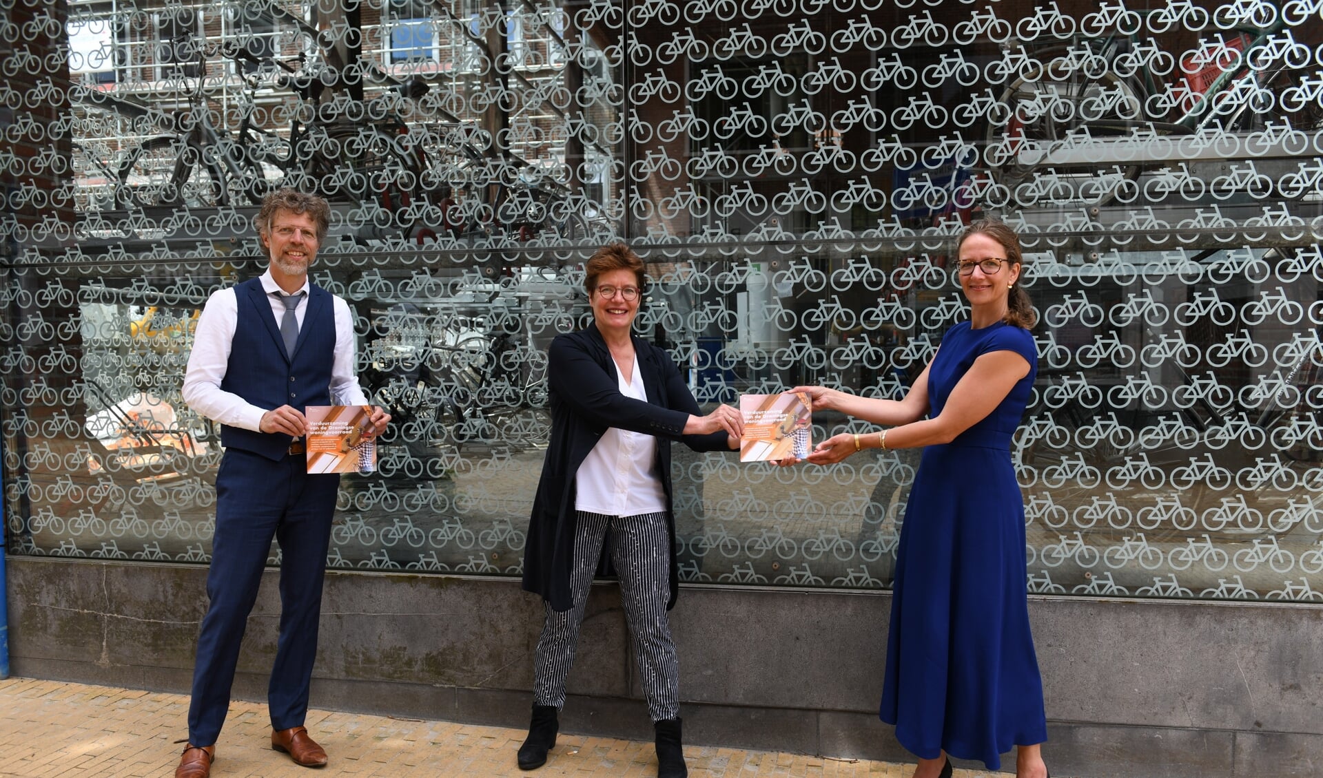 Yvonne Turenhout, directeur-bestuurder van CMO STAMM/Sociaal Planbureau Groningen, overhandigt het rapport aan Ard van der Tuuk en Nienke Homan.