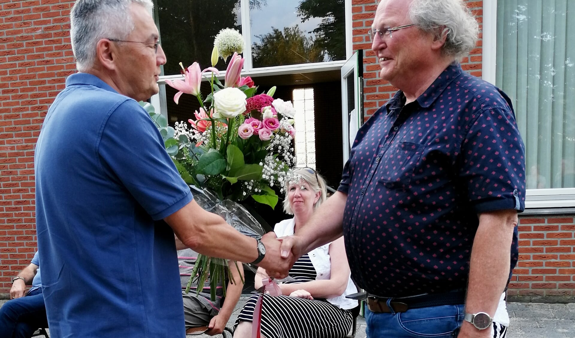 Klaas Withaar (rechts) kreeg als dank voor zijn nooit aflatende inzet een presentje en een boeket bloemen uit handen van voorzitter Francis Boen. (foto: Vocaal Ensemble Chaverim)