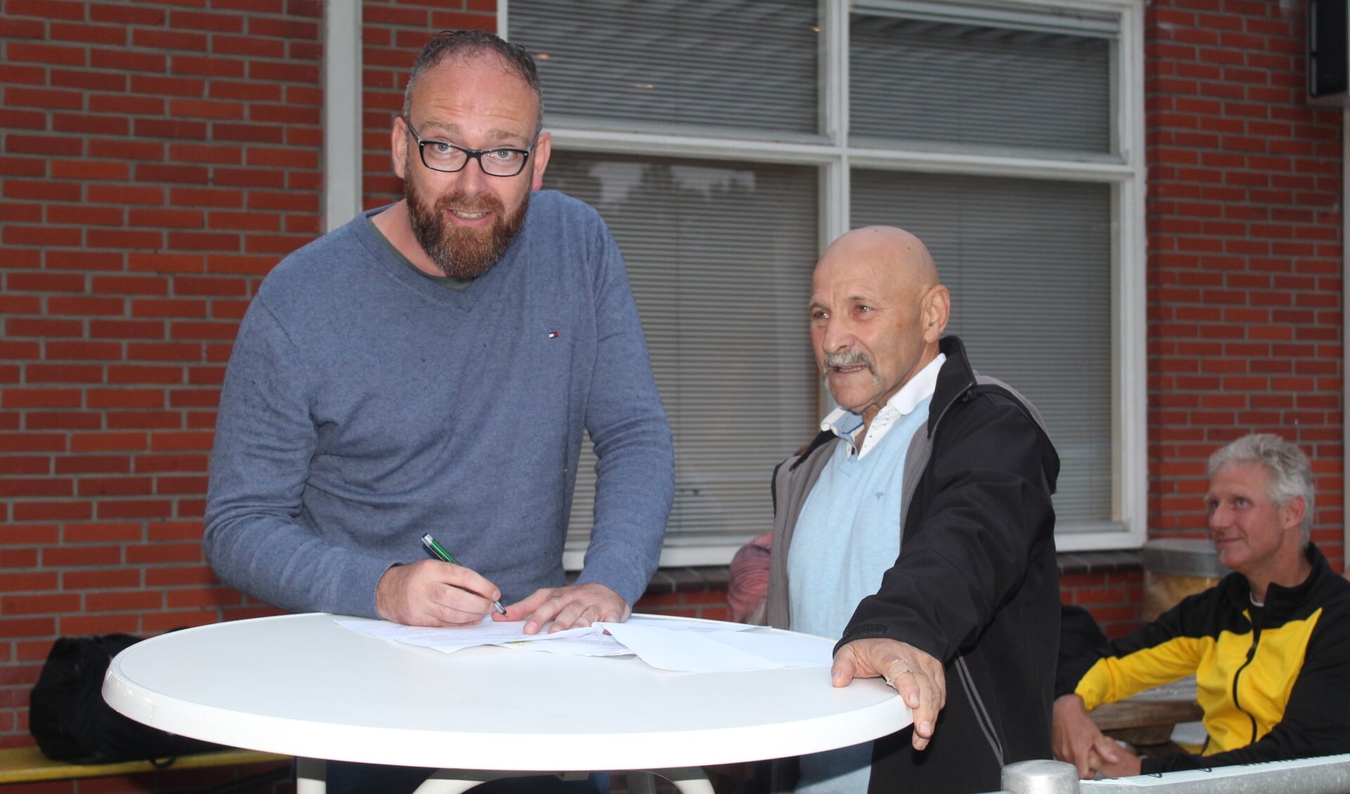 Onder toeziend oog van voorzitter Willem Waals zet trainer Raymond Scholtens zijn handtekening onder het contract. (foto Bert Wierenga)