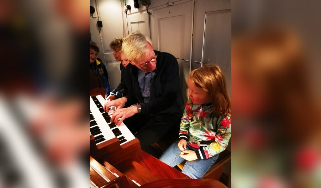 Organist Doewe Kraster geeft in de Grote Kerk uitleg aan jonge fans.