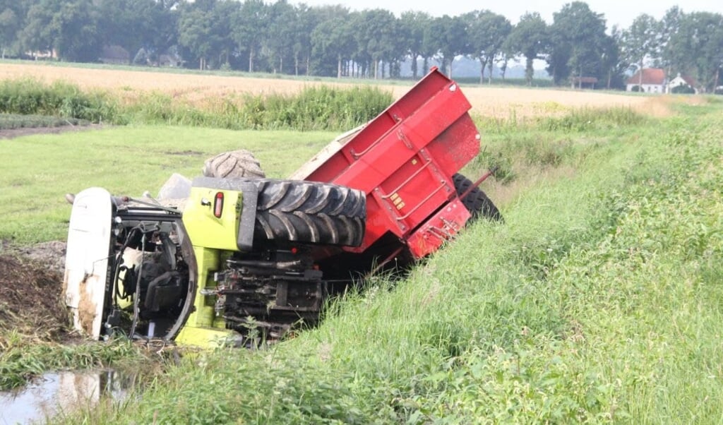Een tractor met aanhanger belandde vanochtend in de sloot langs de Tweederdeweg in Nieuw-Buinen. (foto: Van Oost Media) 