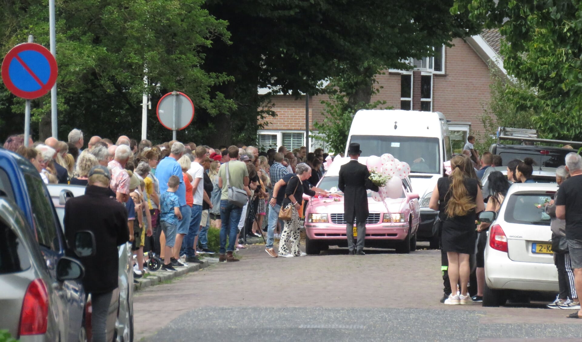 Rijen mensen langs de Meeuwenstraat. Sommigen legden bloemen op de lijkwagen.