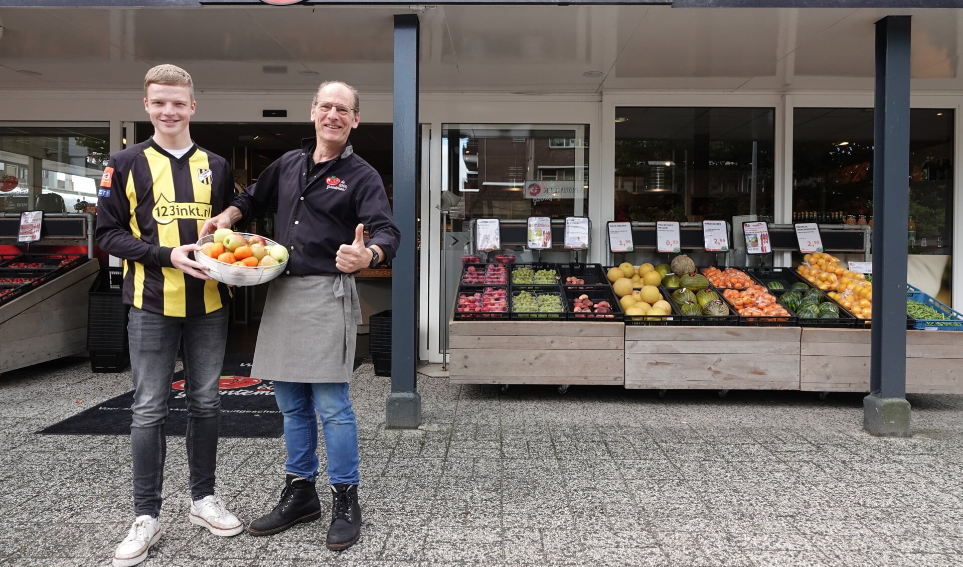 Thijmen Sibma neemt het fruit in ontvangst van groenteman Wim Hofman. Foto: Ada Tolboom