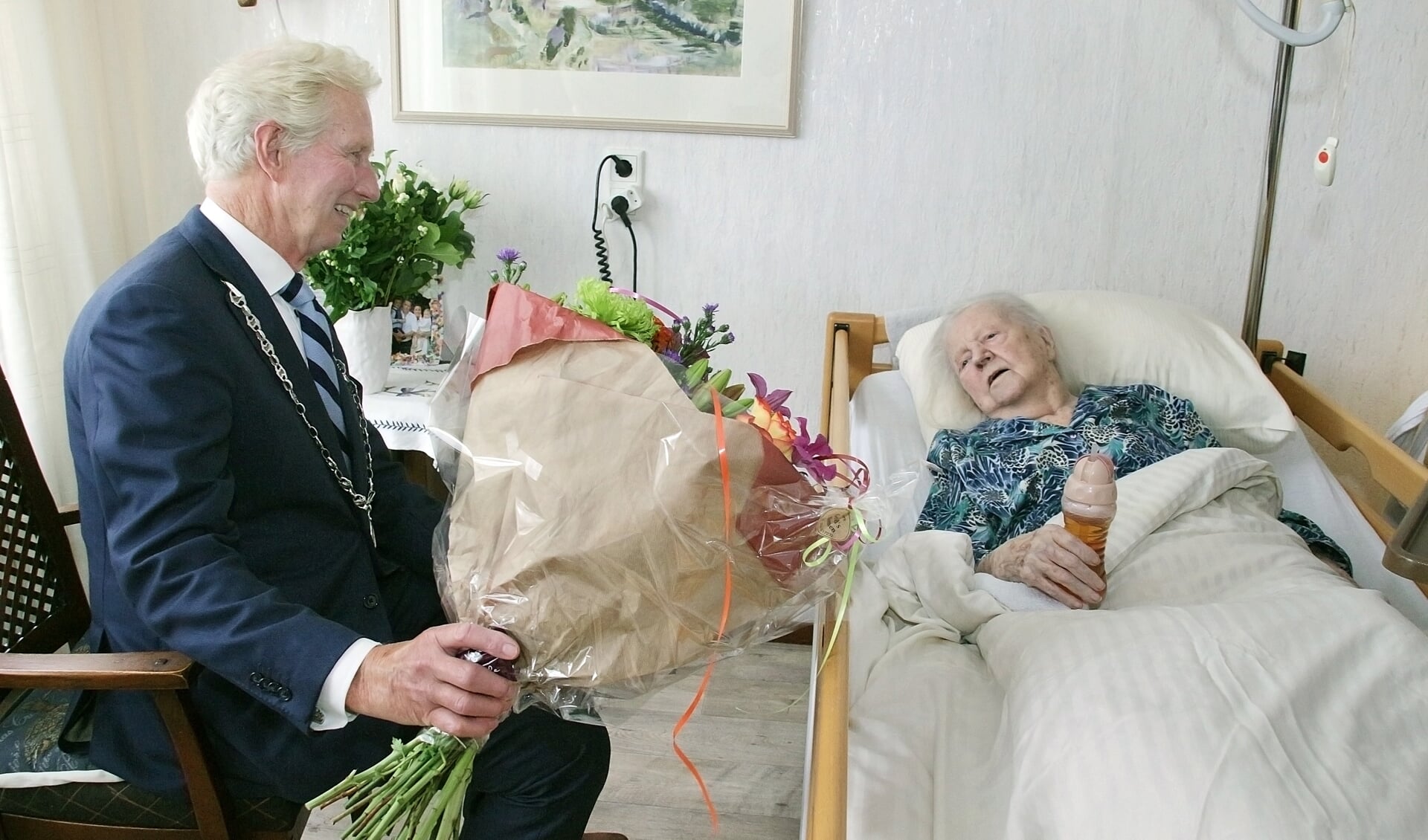 Burgemeester Sipe Swierstra heeft bloemen meegenomen voor de 102-jarige. Foto: Henk Drenth. 