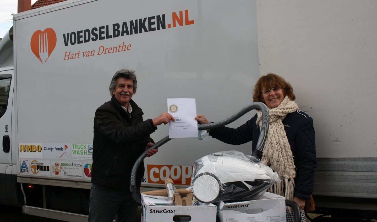 Hilde van Ree van Rotary Club Zuidlaren-Anloo overhandigt de stofzuigers en de cheque aan Frits Haan.