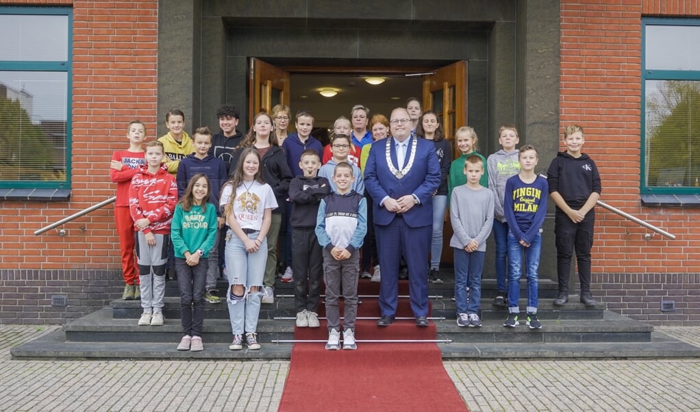 Burgemeester Ben Visser met de kinderen van OBS de Optimist voor het gemeentehuis in Delfzijl.