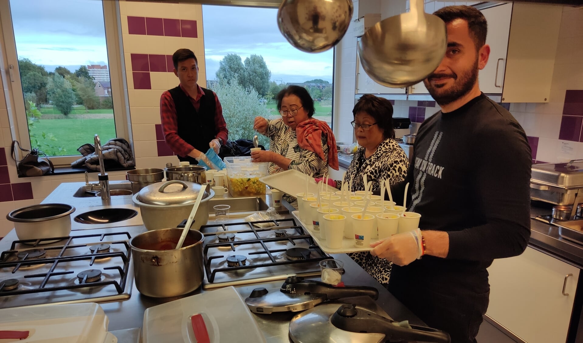 Vrijwilligers van eetclub 't Houkje in actie in de keuken.