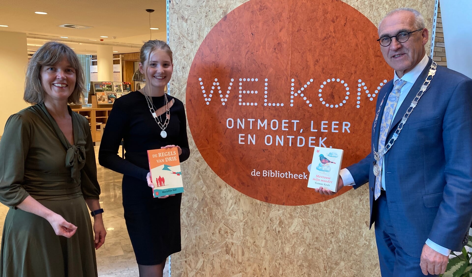 Burgemeester Hoogendoorn en kinderburgemeester Lieke Kruijer krijgen van bibliotheekmedewerker Johanna Roelfsema de eerste exemplaren van Nederland Leest en Nederland Leest Junior overhandigd.