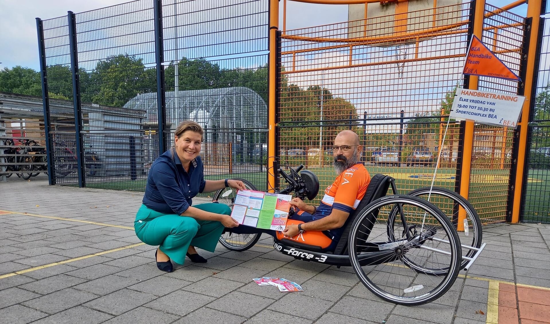 Gedeputeerde Fleur Gräper kreeg bij Beatrixoord in Haren de eerste flyer van de Uniek Sporten Hopper overhandigd door Erik Dodde, handbiker en ambassadeur van Uniek Sporten. (foto: Huis voor de Sport Groningen)