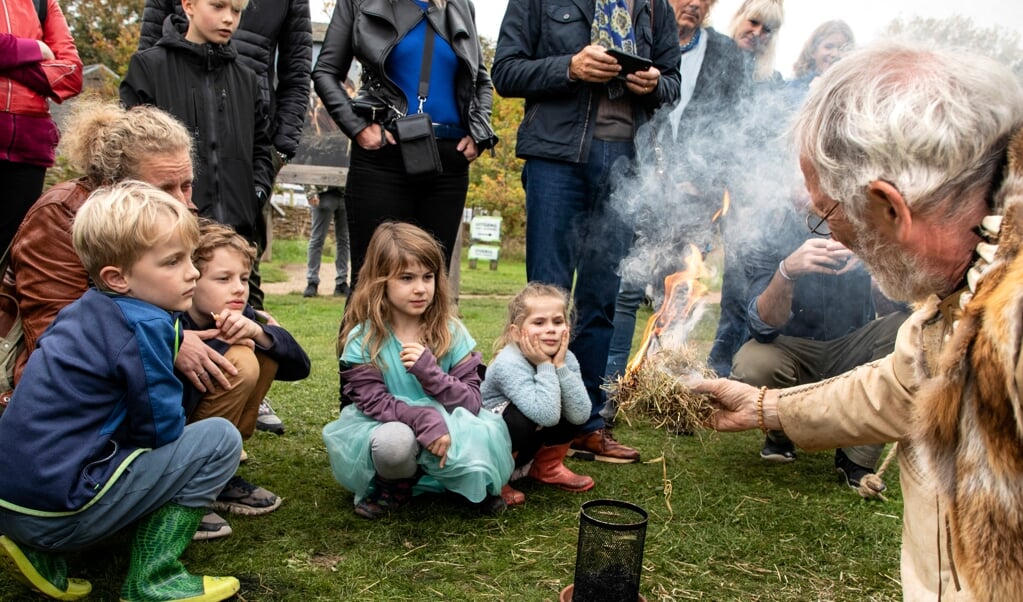 Bezoekers kijken belangstellend toe hoe er vuur kan worden gemaakt. (foto: Auniek Klijnstra)