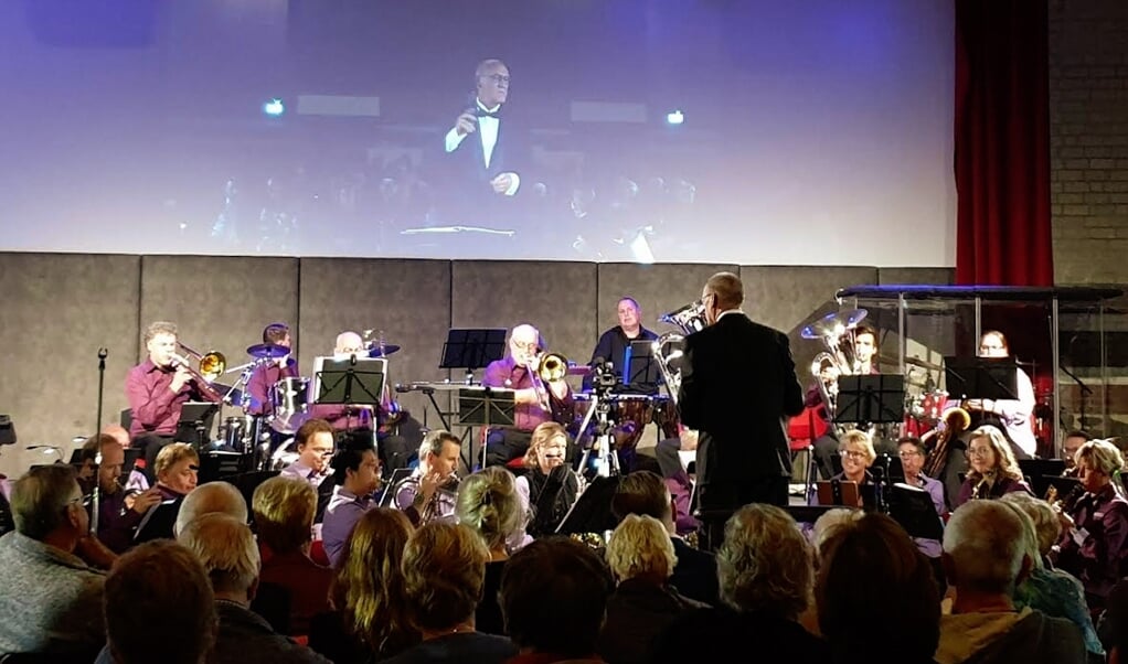Burgemeester Hoogendoorn dirigeert het orkest tijdens de Maestro-avond in (foto: Fanfarecorps HS)