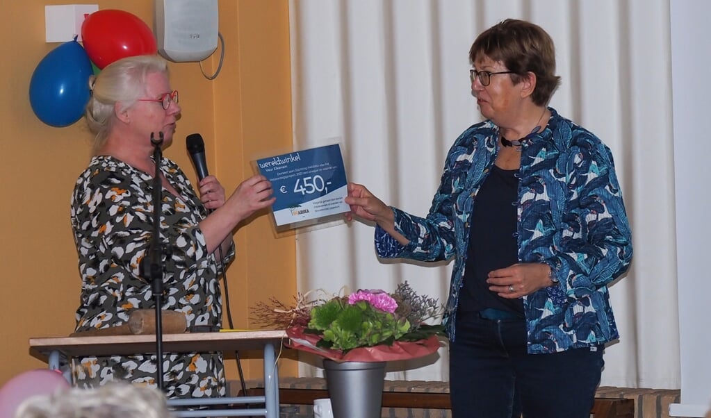 Janet Gorter overhandigt namens de wereldwinkel de cheque aan Ada Bosker van Stichting Imarika.