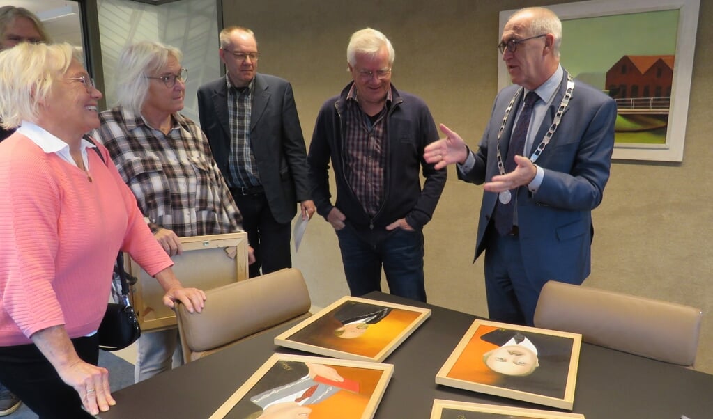 Burgemeester Hoogendoorn bekijkt de portretten, met links de beide dochters van oud-burgemeester Stiekema.
