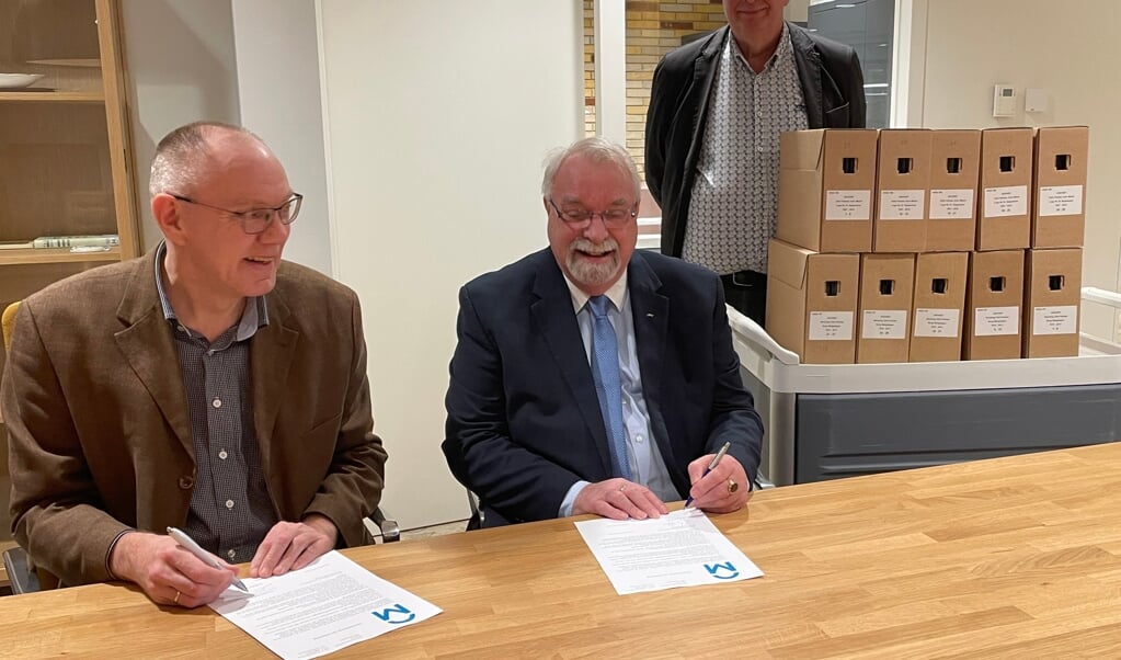 Het tekenen van de akte van overdracht door Teade Smedes (links) en Pian van Akker, voorzitter van de John Welch Loge. Op de achtergrond Harry Driest, voorzitter van de archiefcommissie van de herenloge.