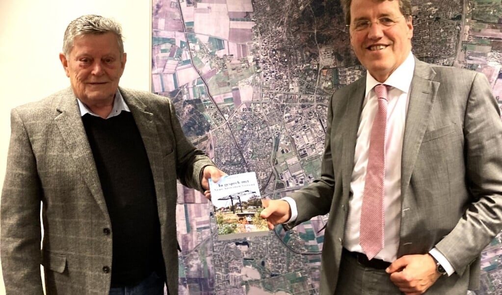 Aad Vrijhof (links) met burgemeester Eric van Oosterhout en zijn nieuwste boek.