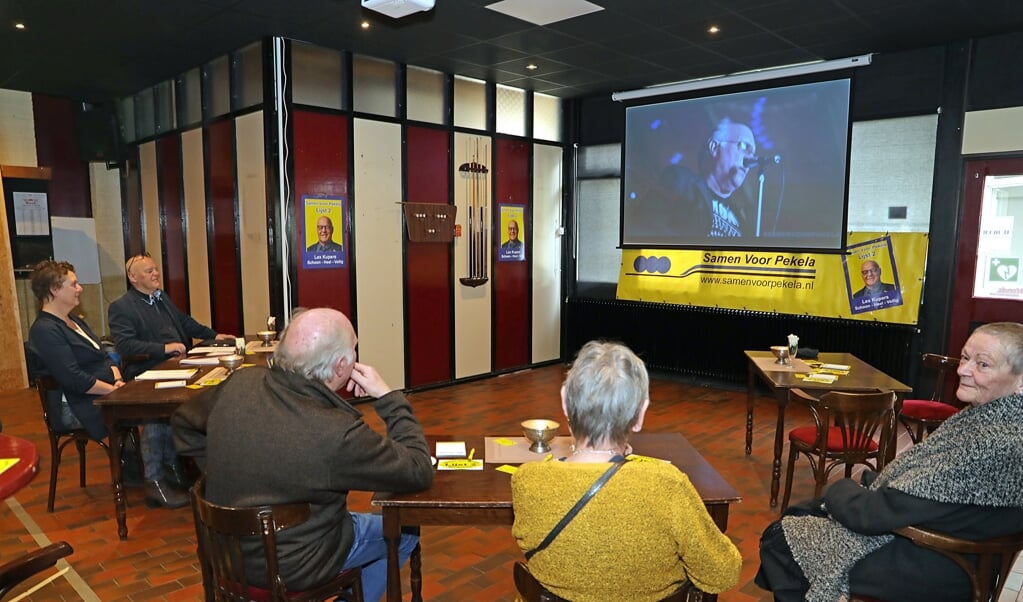 Leden van Samen Voor Pekela kijken naar de zojuist gelanceerde videoclip. Foto: Bert Woltjes. 