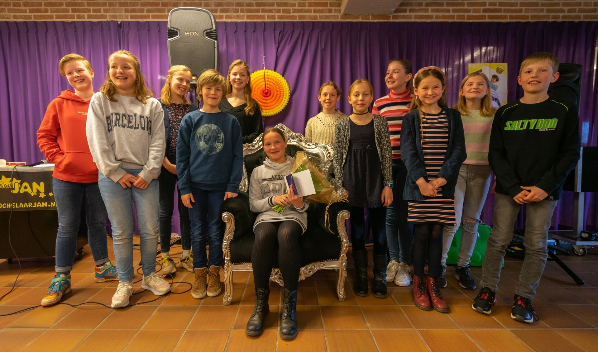 De deelnemers aan de voorleeswedstrijd, met op de stoel winnaar Sophie Bomhof. (foto Liam Kuiper/LK Media)