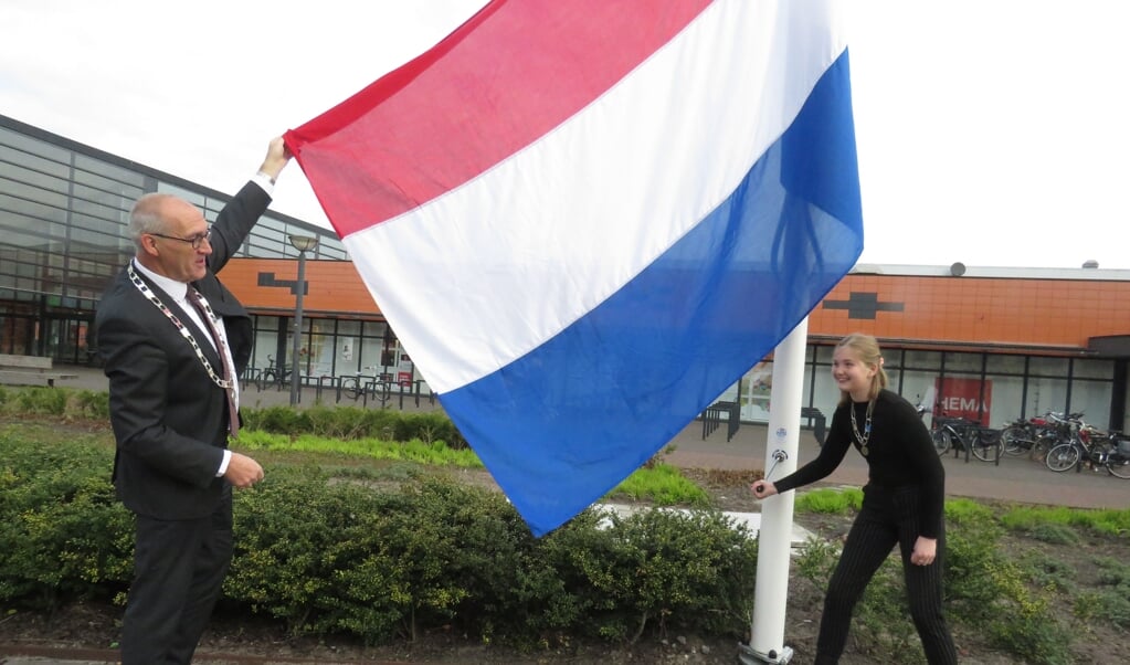 Burgemeester Hoogendoorn en Lieke Kruijer hijsen de vlag.