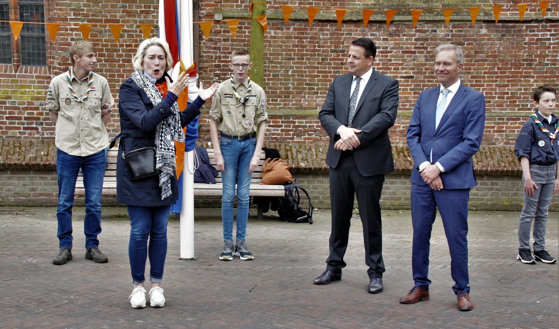 Annalies Usmany is bezig aan haar toespraak. Toehoorders zijn onder anderen voorzitter Rody Bos van de Oranjevereniging Appingedam en wethouder Meindert Joostens (foto Jan A. Blaak).