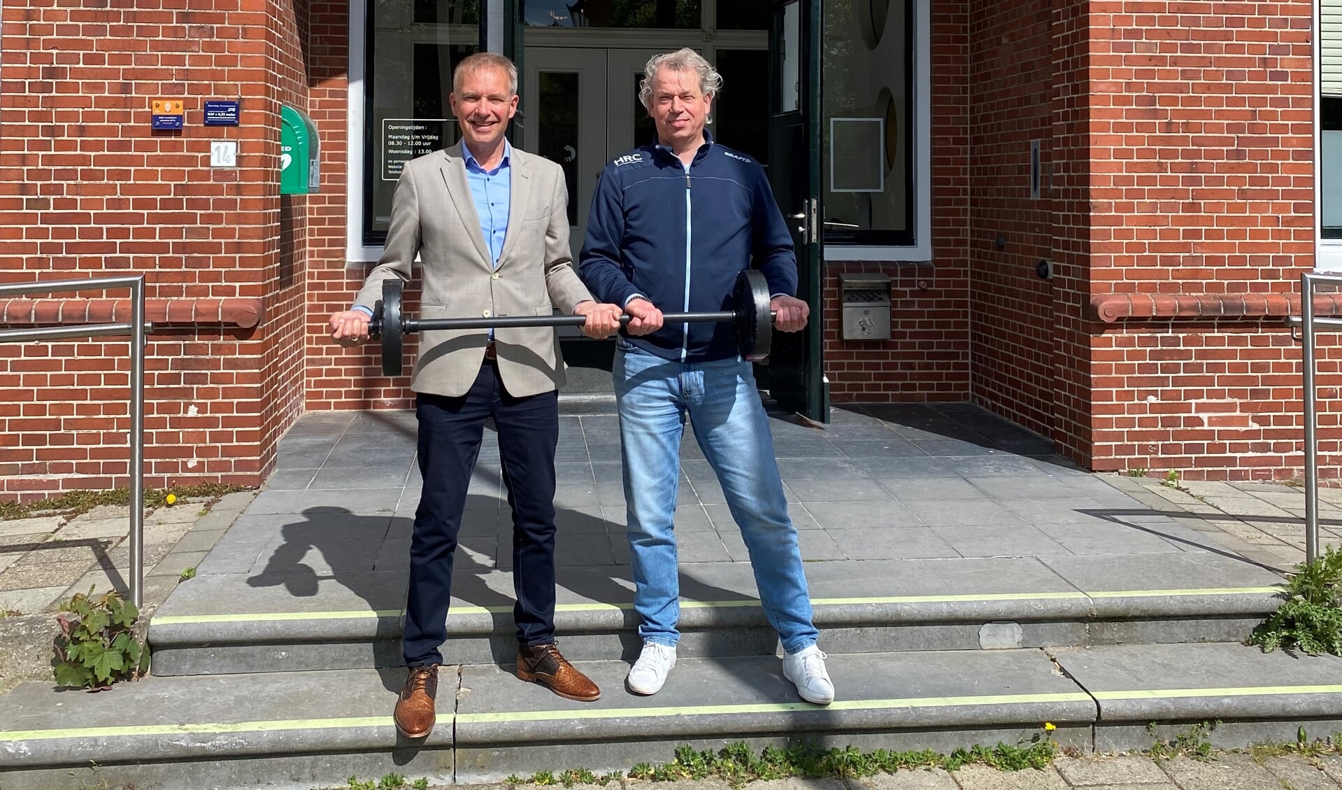 Meindert Joostens en Jeroen Laarhuis (HRC Powerful Ageing) tillen gezamenlijk een halter om de samenwerking te bekrachtigen.