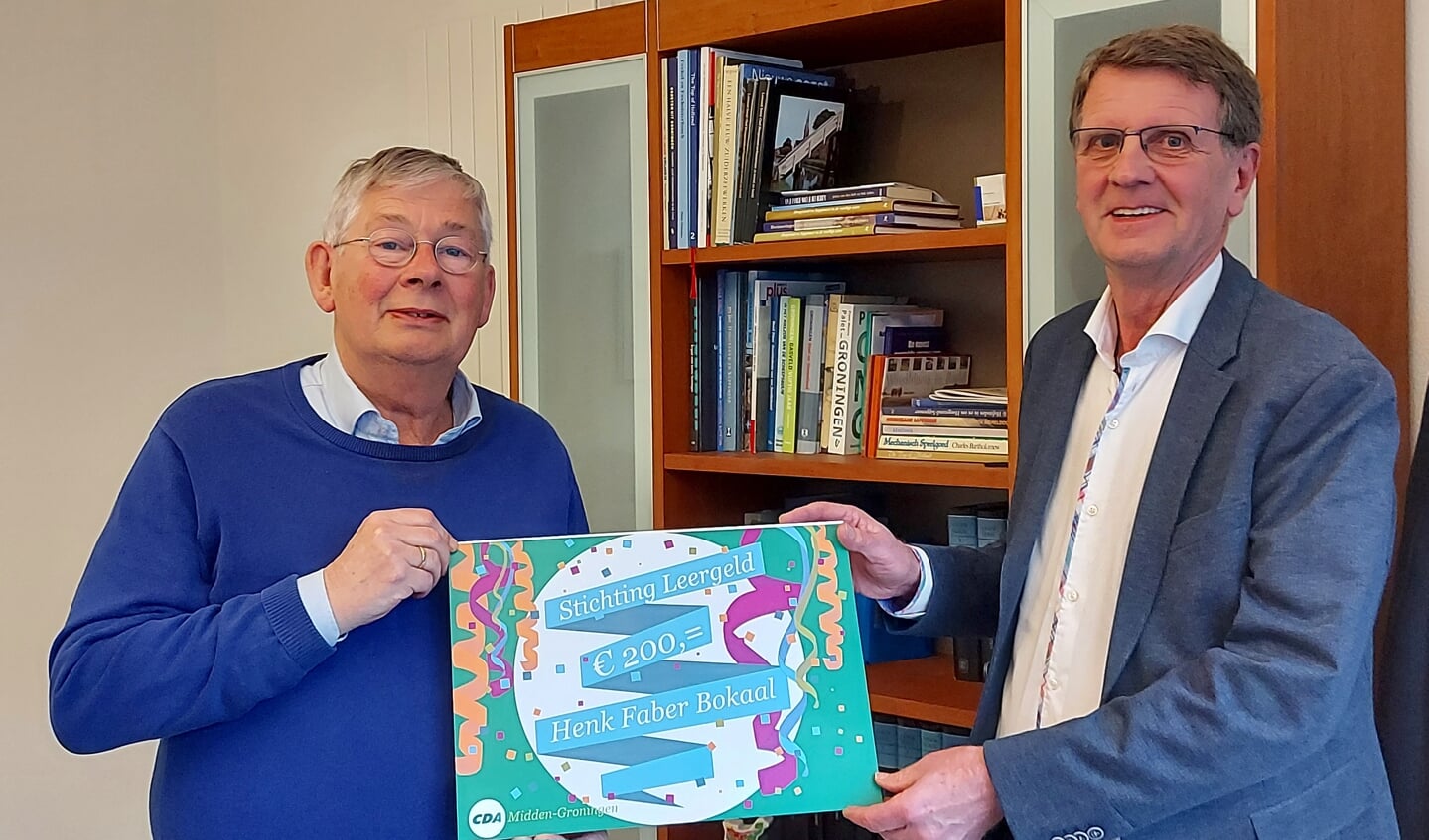 Henk Wiersema (rechts) overhandigt de cheque aan Stichting Leergeld Midden-Groningen.