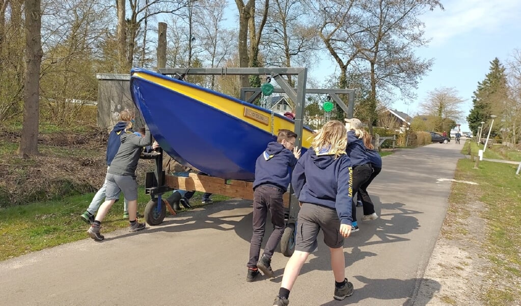 Leden van Waterscouting Nicolaasgroep brengen één van de boten naar het water.