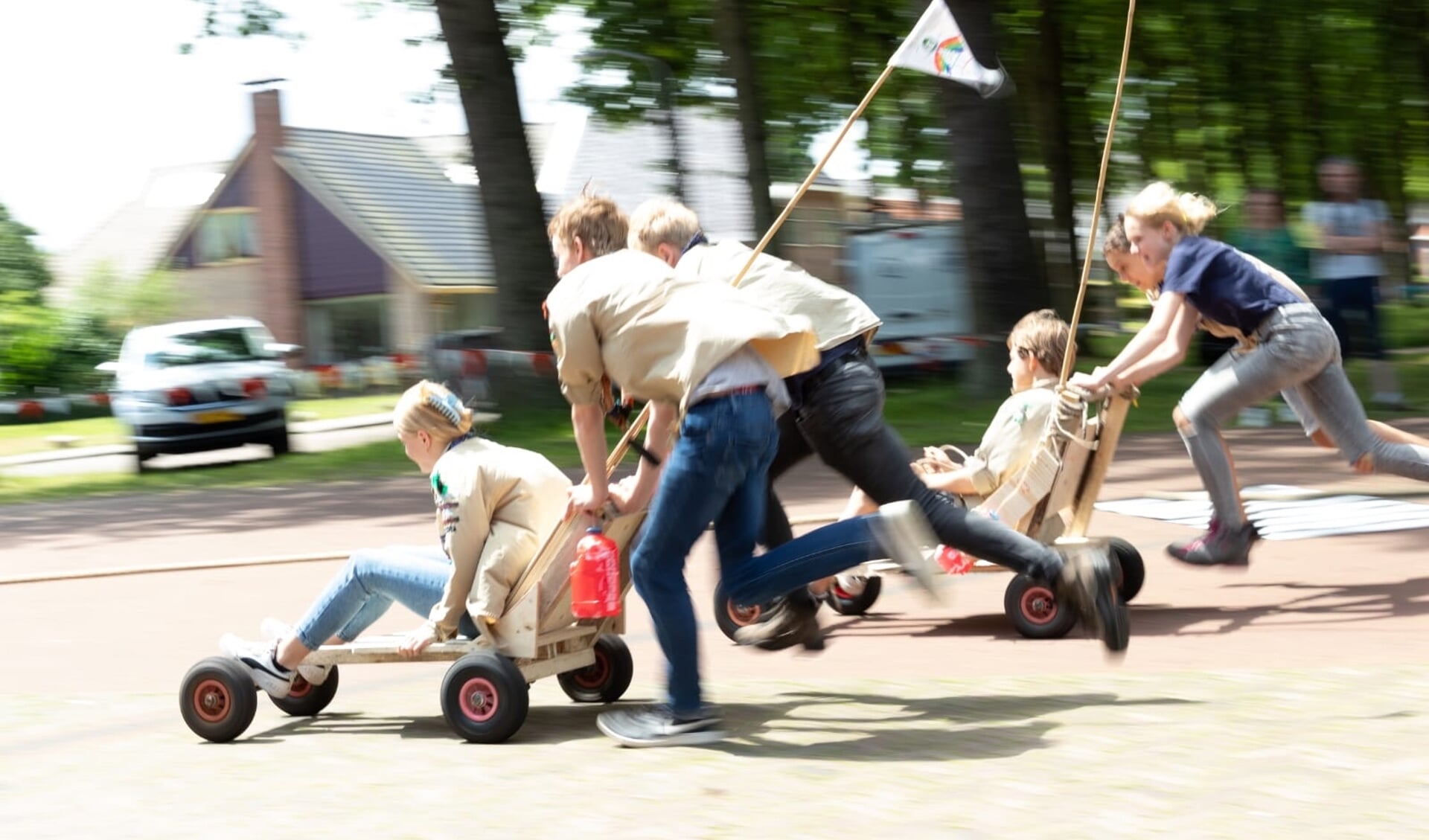 Scouts scheuren met hun zelfgebouwde raceauto's over de Brink in Zuidlaren.