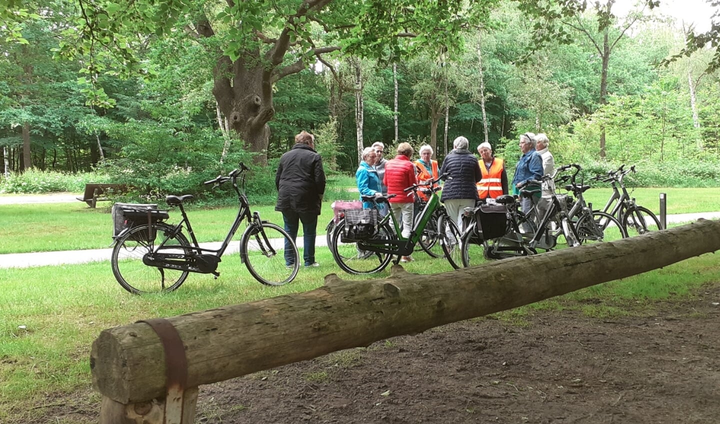 De deelnemers aan de fietstocht pauzeren even in het bos.