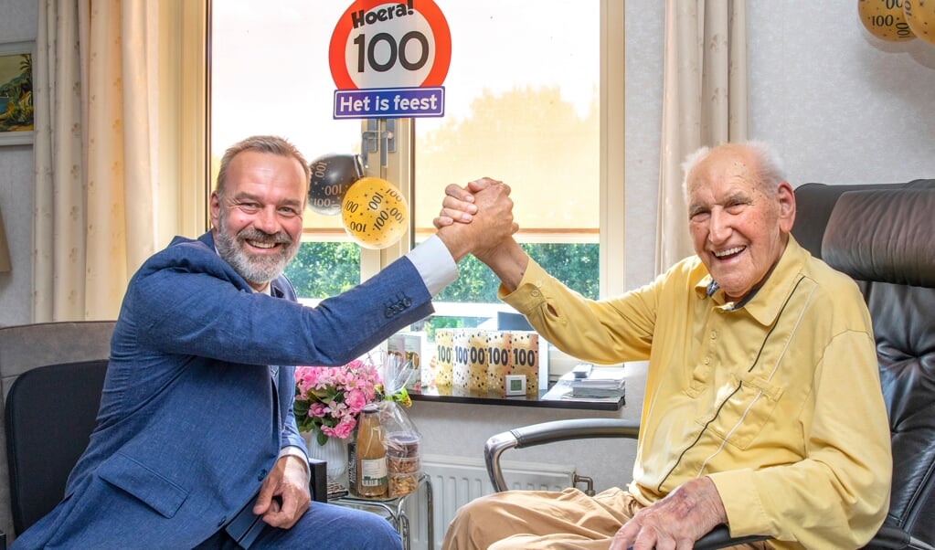 Burgemeester Klaas Sloots feliciteert Piet Poelhekke met zijn 100e verjaardag. (foto: Auniek Klijnstra)