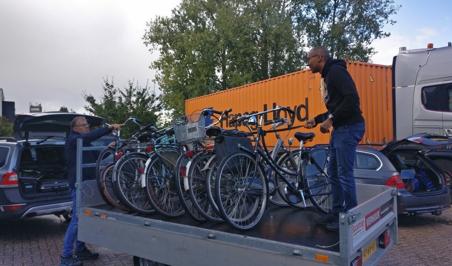 De Lions Wim Kroeze en Jermaine Camron laden de geschonken fietsen uit bij de werkplaats.