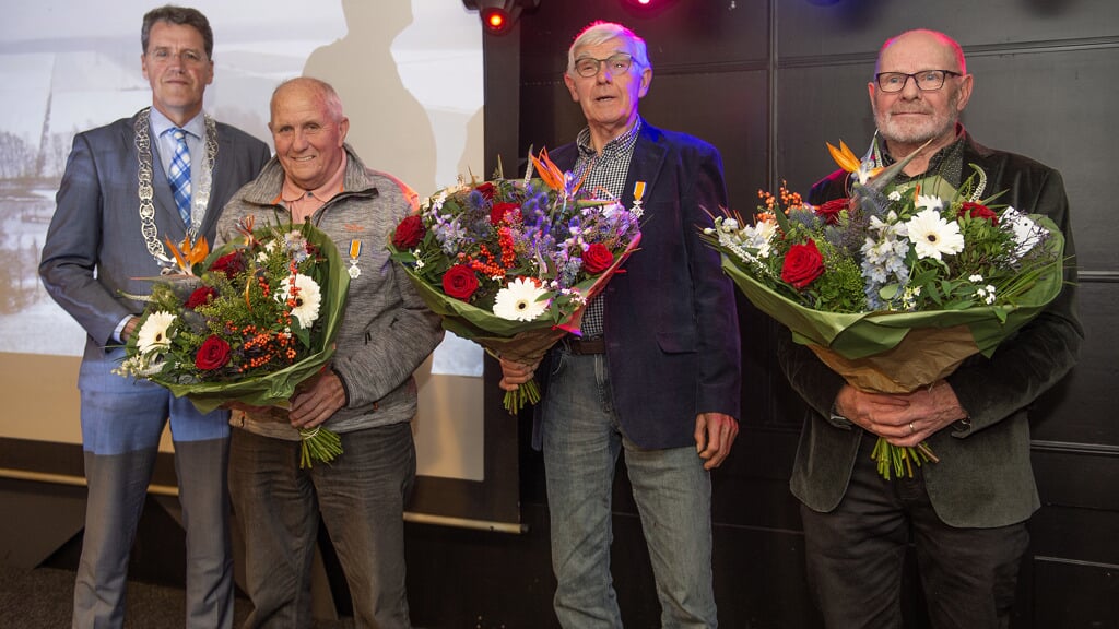Herman Suelmann, Johan Siekman en Herman Ottens met de onderscheidingen, bloemen en burgemeester Eric van Oosterhout (foto Gemeente Emmen).