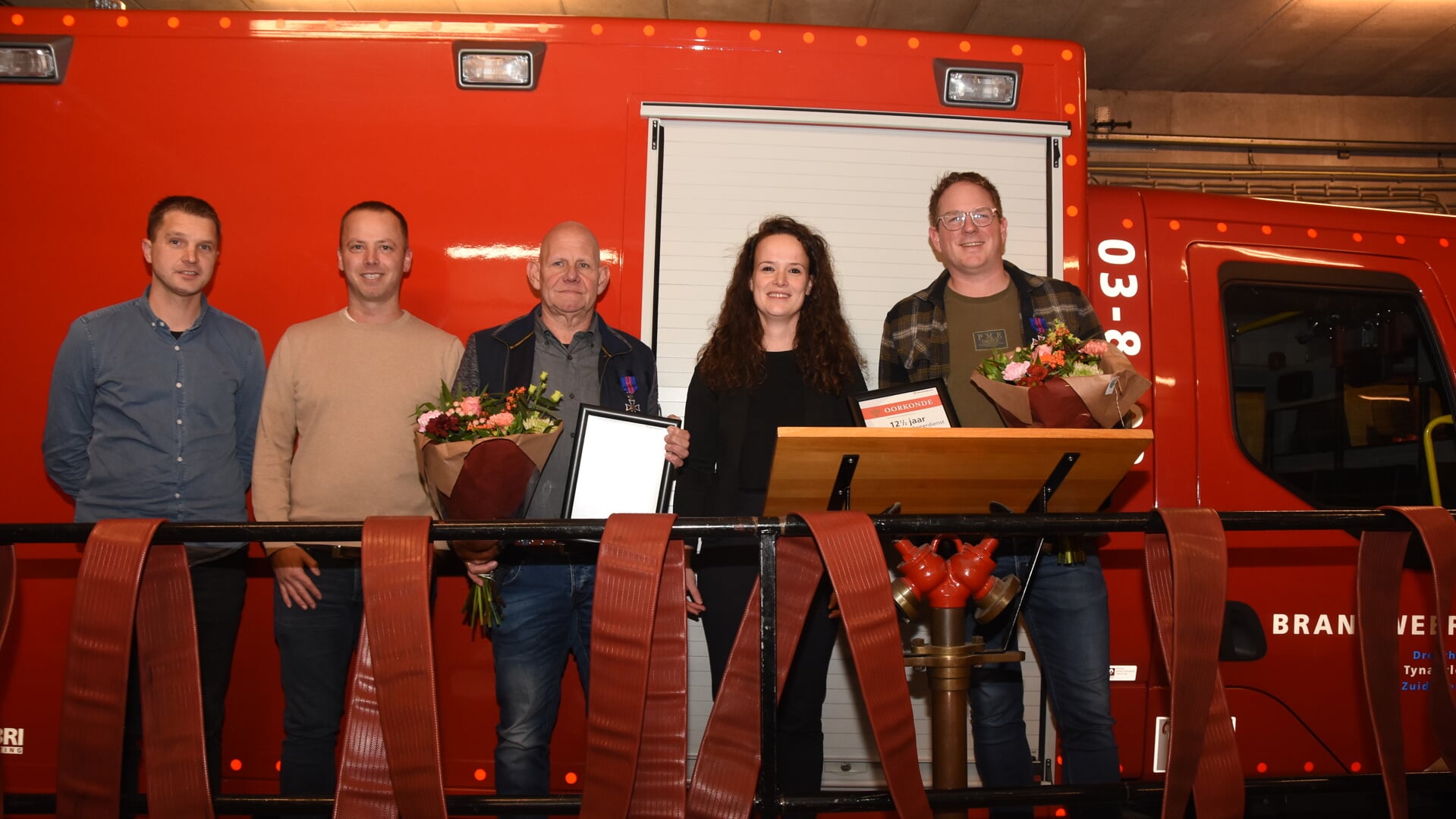 Postleden van Brandweer Zuidlaren en Sonja Kesselmans (Brandweer Drenthe) hebben jubilarissen Lukas Koops (midden) en Harmannus Heeres (rechts) in het zonnetje gezet. (foto: Arjen Kuiper)