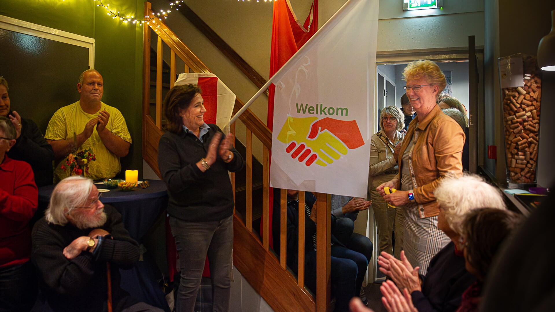 Wethouder Kiena ten Brink (rechts) geeft het startschot van het project Naoberschap Anloo. Links van de vlag voorzitter Jacqueline Steinmetz van Dorpsbelangen.