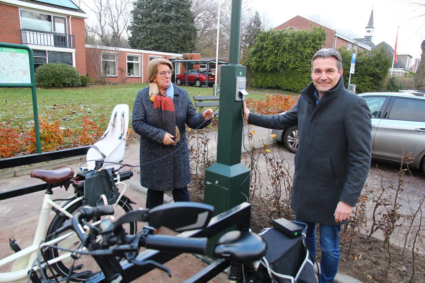 Wethouders Nienke Houwing en Ivo Berghuis hebben hun fietsen aan de laadpaal gelegd. 