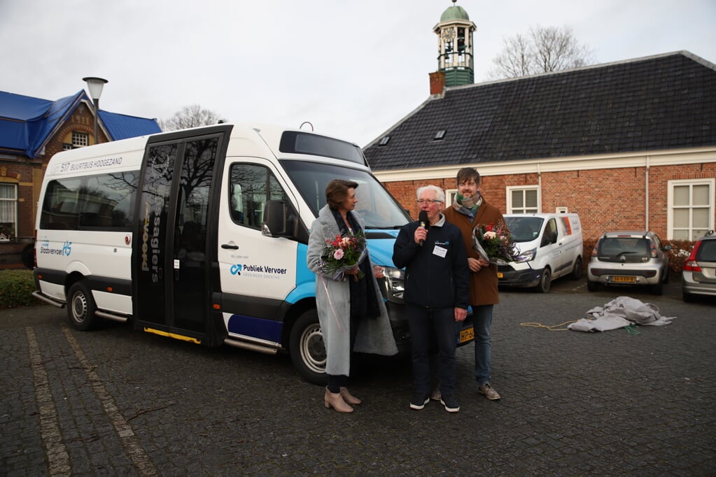 De feestelijke start van lijn 517. Bloemen voor wethouder Hoesen, terwijl stichtingsvoorzitter Frans Smid de aanwezigen toespreekt. (foto: Francisca Venema)