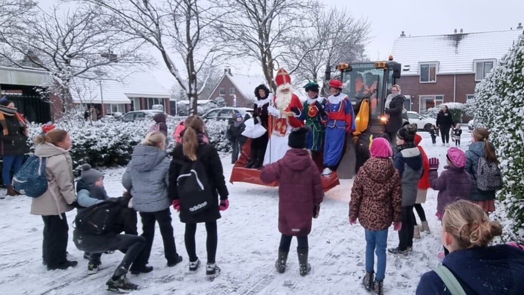 Sinterklaas arriveert, samen met drie Pieten, in een shovel op de Veendammer school. 