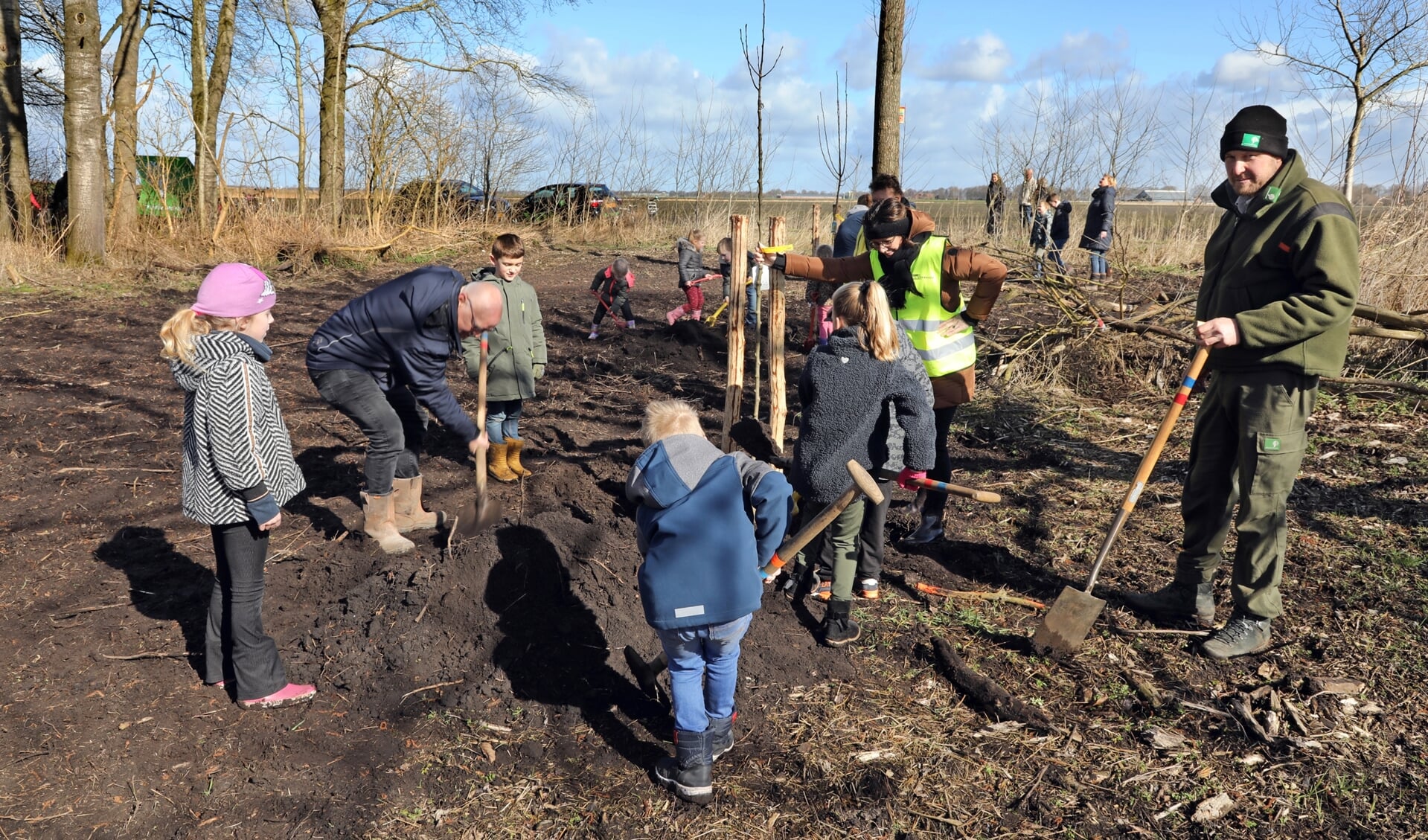 Leerlingen van de Theo Thijssenschool planten samen met wethouder Lex Kupers bomen bij het Hoetmansmeer. Foto: Bert Woltjes.
