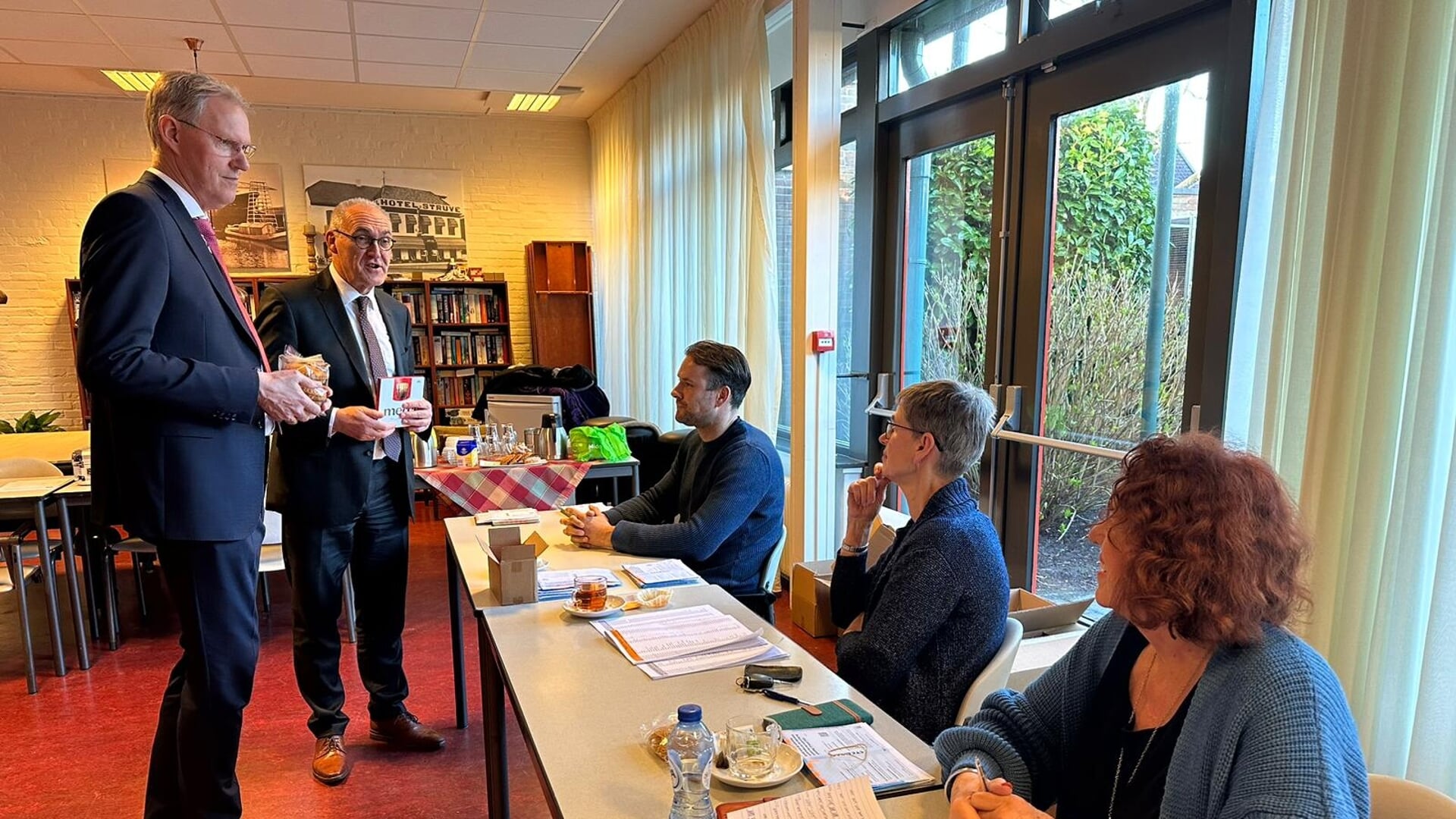 Burgemeester Adriaan Hoogendoorn en dijkgraaf Geert-Jan ten Brink brengen chocolaatjes mee voor de leden van het stembureau. (foto: gemeente Midden-Groningen)