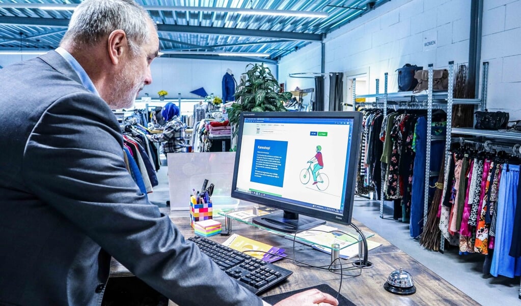 Wethouder Hans Ronde geeft bij Kledingbank Maxima in Appingedam het startsein voor de Kansshop.