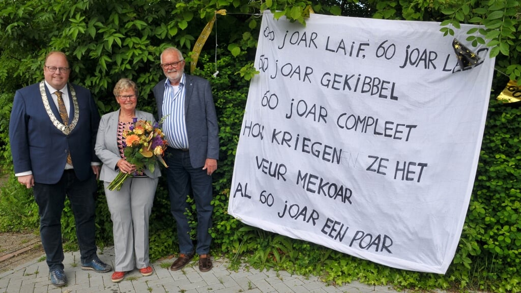 De heer en mevrouw Elzerman samen met burgemeester Ben Visser bij een spandoek dat gewijd is aan het huwelijksjubileum.