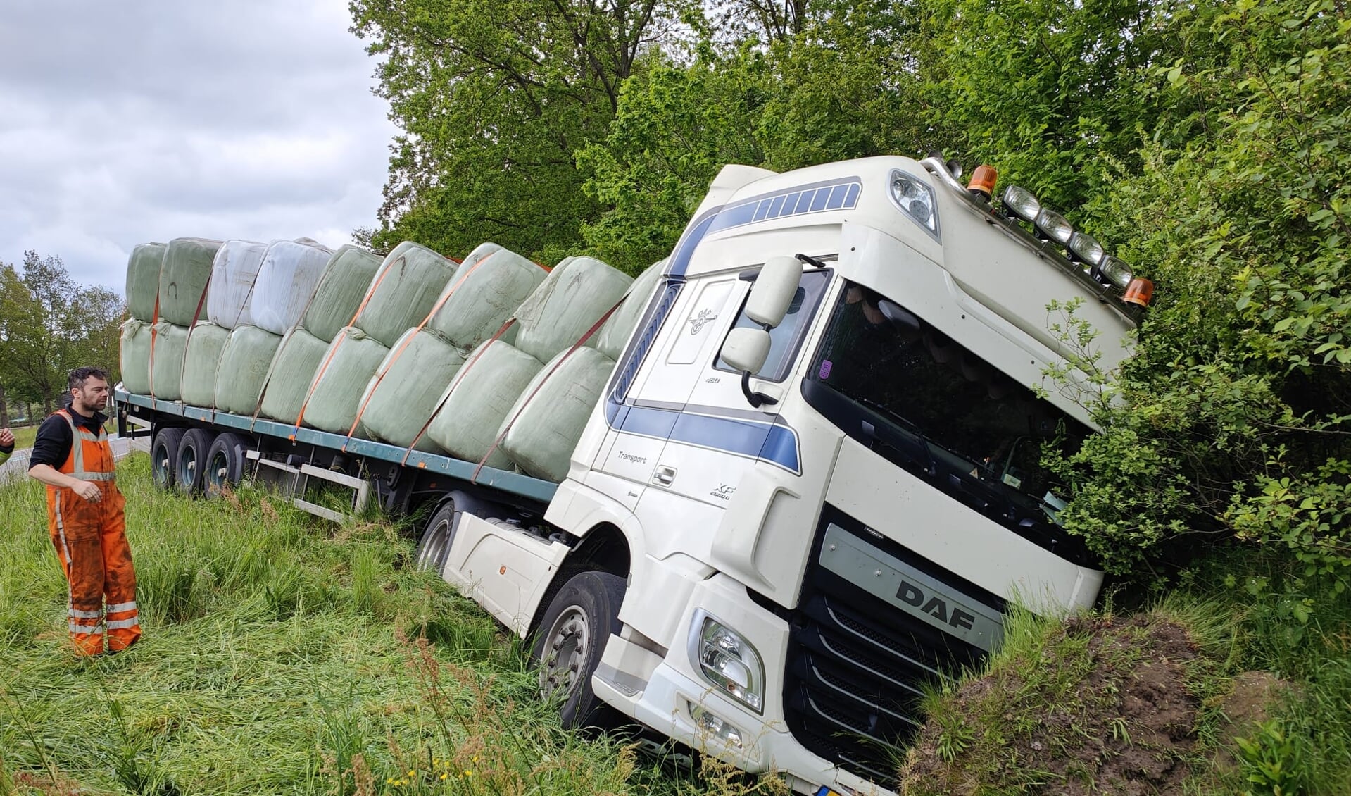 De vrachtwagen, beladen met strobalen, kwam door onbekende oorzaak in de sloot langs de N34.