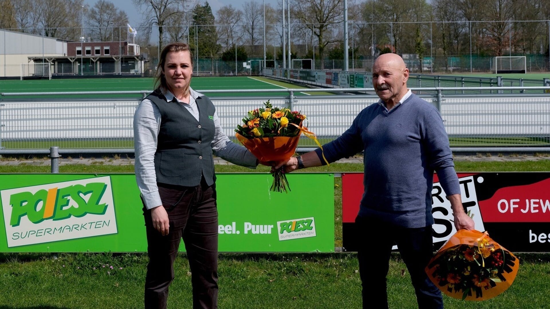 Danielle Wesenhagen, Poiesz-vestigingsmanager in Zuidbroek, bekrachtigt de nieuwe overeenkomst met Kwiek-voorzitter Willem Waals met een fleurig boeket.