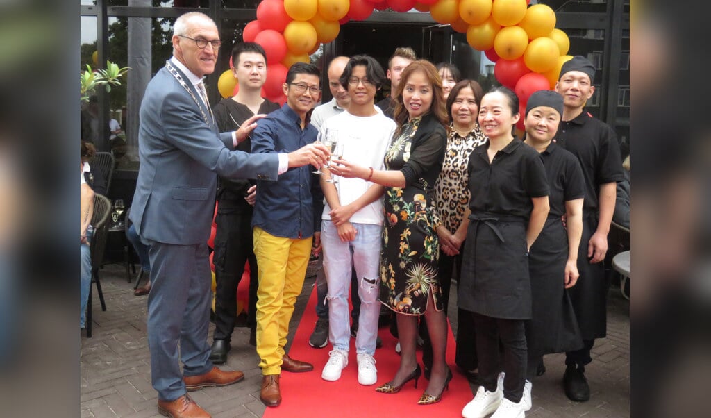 Burgemeester Hoogendoorn met de heer en mevrouw Liu en het team van medewerkers na de officiële opening.