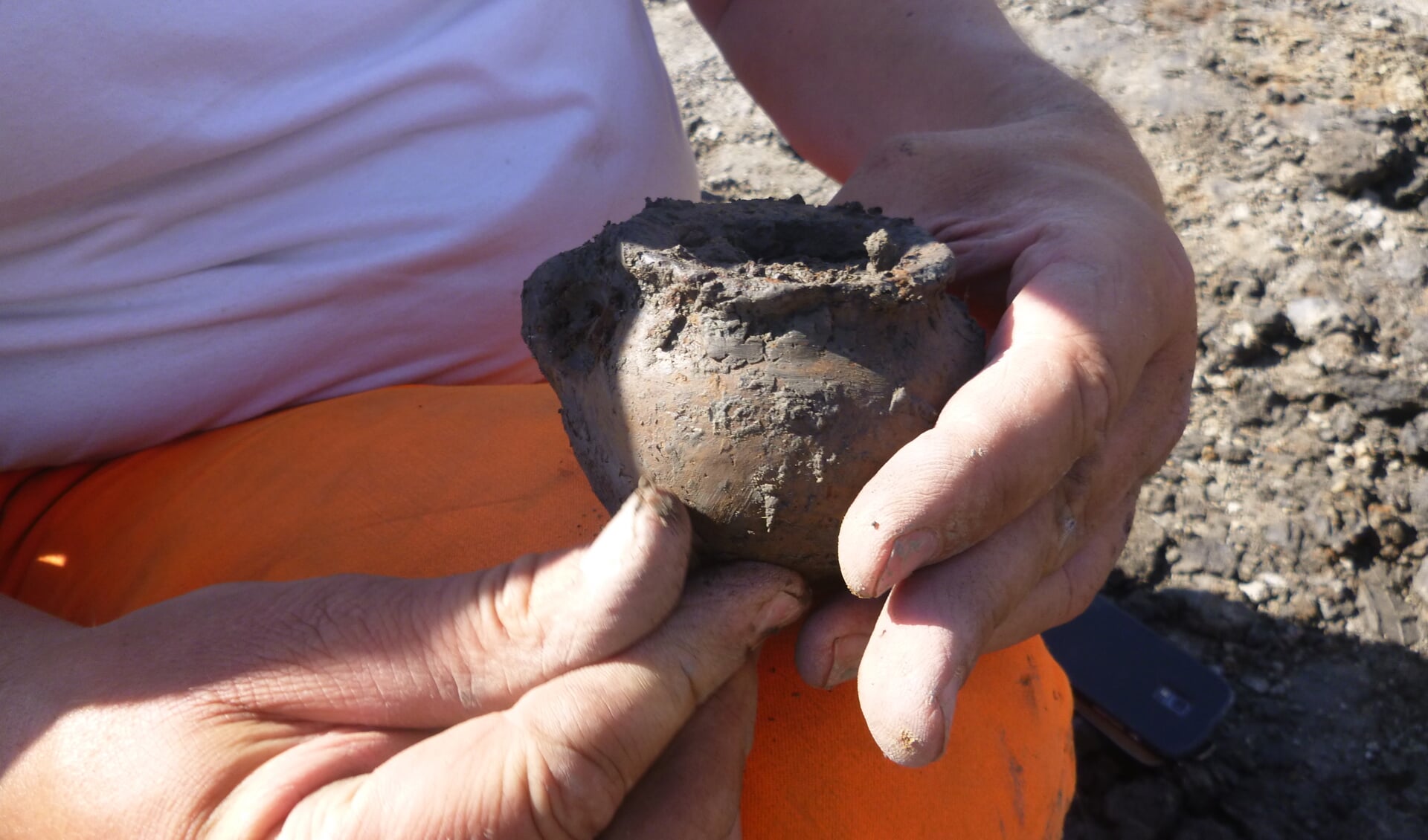Een archeoloog graaft een pot op, op de locatie van de onbekende wierde. Foto: Antea Group.