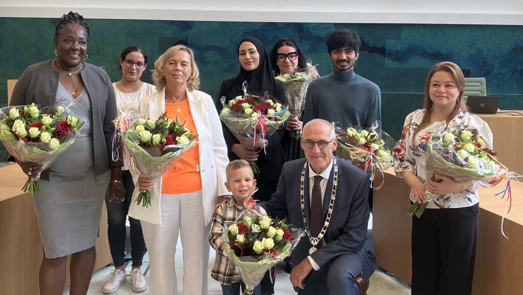 De nieuwe Nederlanders met de bloemen en burgemeester Hoogendoorn.