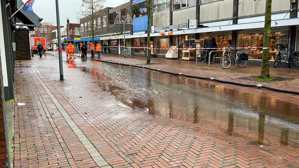 De Schoolstraat in Delfzijl. De riolering kan het vele regenwater niet meer aan en een deel van de straat staat blank.