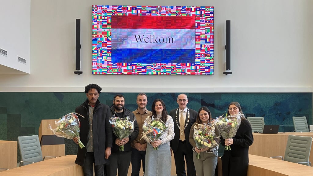 De zes nieuwe inwoners met de burgemeester en de bijbehorende bloemen. (foto: gemeente Midden-Groningen)